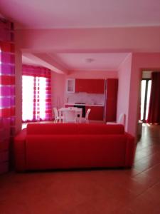 a living room with a red couch and a table at Tus'Hotel in Castel di Tusa