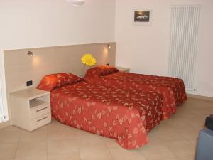 1 dormitorio con 2 camas con sábanas rojas y una flor amarilla en Bassini Residence, en Bolonia