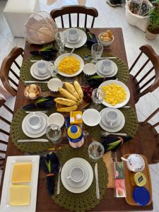 a wooden table with plates of food on it at Casa Pipa Charme do Amor in Pipa