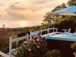 a garden with a pool and flowers and an umbrella at Residenza B&B VistaMare in Petacciato