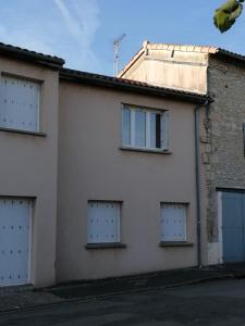 un edificio blanco con cuatro puertas de garaje. en Appartement meublé proche du futuroscope, en Poitiers