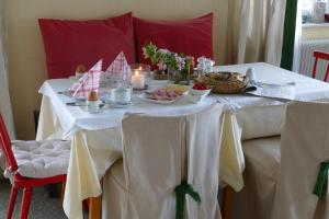 Una mesa blanca con comida y velas. en Pension Geissler-Reicher, en Oberwölz Stadt