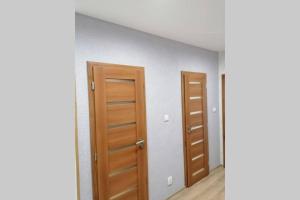 duas portas num quarto vazio com pisos de madeira em Apartmán blízko hlavnej stanice a centra mesta em Bardejov