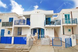 a white house with blue balconies and blue gates at GD Case Vacanza - Fronte Mare - in Lido Marini