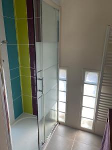 ルヴィエにあるMaison Thorelのカラフルなタイル張りのガラス張りのシャワー付きのバスルーム