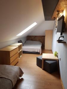 a small bedroom with a bed and a desk and a tv at Na Stawach in Stryszów