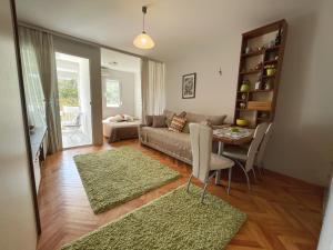 een woonkamer met een bank en een tafel met tapijten bij Studio Apartment Irena in Sutomore