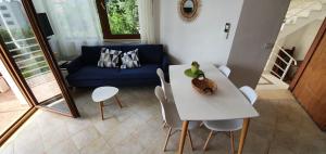 a living room with a table and a blue couch at Seaview apartment in Borsh
