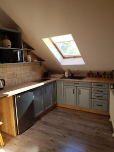 a kitchen with a skylight in the ceiling with a sink and a stove at Na Stawach in Stryszów