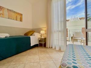 a bedroom with a bed and a balcony at Hotel Sikania in San Vito lo Capo