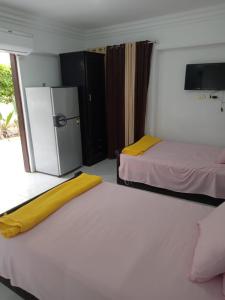 um quarto com 2 camas e um frigorífico em R1 CH21 studio 2 beds poolside garden terrace Green Beach em El Alamein
