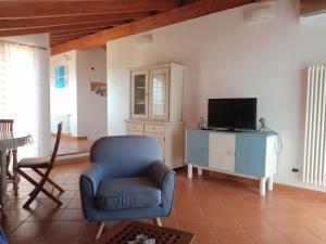a living room with a blue chair and a tv at La Gora, tra mare e sentieri in Lerici