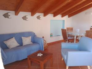 Una sala de estar con un sofá azul y una mesa. en La Gora, tra mare e sentieri, en Lerici