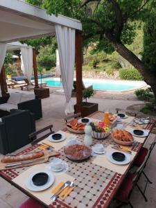 una mesa con comida junto a una piscina en Mas Lei Bancau, en Le Beausset