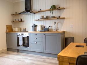 a kitchen with a stove and a sink and a table at Cruinn Bheinn Luxury Self Catering Apartments in Portree