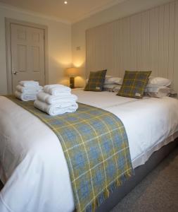 1 dormitorio con 2 camas y toallas. en Cruinn Bheinn Luxury Self Catering Apartments en Portree