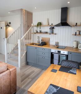 a kitchen with blue cabinets and a stair case at Cruinn Bheinn Luxury Self Catering Apartments in Portree
