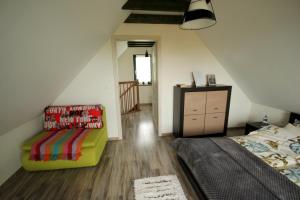 a bedroom with a bed and a chair in a attic at Bajkowy domek in Lubin
