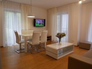 comedor con mesa, sillas y TV en Apartament Mondi Kai I - idealny na pobyt w górach, en Szklarska Poręba