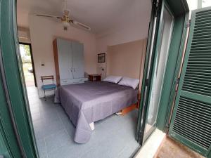 1 dormitorio con cama y ventana en Nel villaggio il Monolocale tra gli ulivi, en SantʼAndrea Apostolo dello Ionio