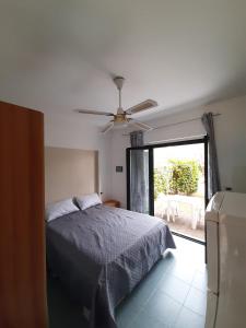 a bedroom with a bed and a ceiling fan at Nel villaggio il Monolocale tra gli ulivi in SantʼAndrea Apostolo dello Ionio