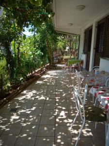 a patio with tables and chairs and trees at Vila Umicevic in Bijela