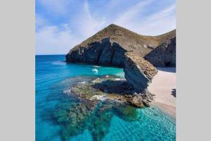 a beach with a rock formation in the water at Finca Villa Clara Cabo de Gata Nijar Almeria in El Viso