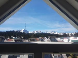 a view from a window of a city with snow covered mountains at Apartment Durmitor fairy in Žabljak