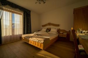 a bedroom with a bed and a large window at Hotel Stauder in Dobbiaco