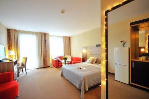 a hotel room with a bed and a mirror at DOBRUK APARTAMENTY "DIWA"" w CZTEROGWIAZDKOWYM HOTELU in Kołobrzeg
