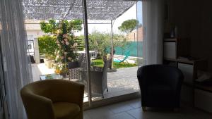 a living room with two chairs and a sliding glass door at Le Pré Aux Cigales in Uzès