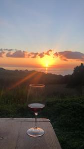 una copa de vino sentada en una mesa con la puesta de sol en Monolocale Pisturri en Magomadas