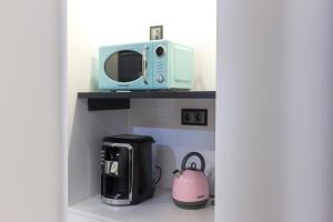 a microwave sitting on a shelf next to a coffee maker at Taska Vila Velha in Mirandela