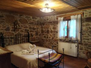 1 dormitorio con cama y pared de piedra en La Casa Del Llano en Olocau del Rey