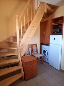 a staircase in a kitchen with a washer and dryer at Kertész Vendégház in Hegykő