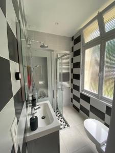 uma casa de banho com um chuveiro e um lavatório branco em Le Charles VII - VIENNE em Chinon
