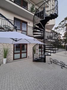 a building with a staircase and a white umbrella at Villa Lordis in Krynica Morska