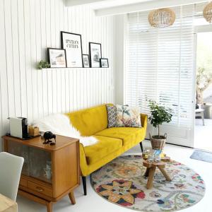 een woonkamer met een gele bank en een tafel bij Beach House For You - Luxe verblijf, 5 min van het strand in Katwijk aan Zee