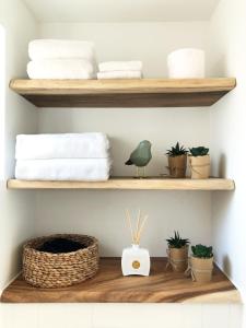 a room with wooden shelves with towels and plants at Beach House For You - Luxe verblijf, 5 min van het strand in Katwijk aan Zee