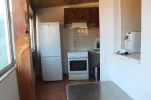 a kitchen with a white refrigerator and a stove at COZY HOUSE in Fão