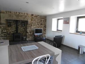 a room with a table and chairs and a fireplace at Les Mouettes in Plouër-sur-Rance