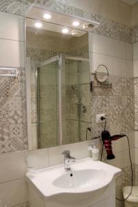 ein Bad mit einem Waschbecken, einer Dusche und einem Spiegel in der Unterkunft MEDUSA Residence B&B in Margherita di Savoia
