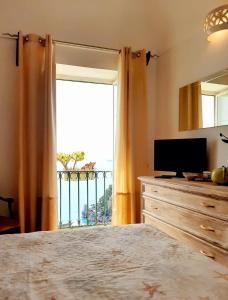 ein Schlafzimmer mit einem Bett und einem großen Fenster in der Unterkunft A la casa del cavaliere in Positano