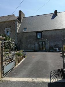 a brick house with a driveway in front of it at Les Mouettes in Plouër-sur-Rance