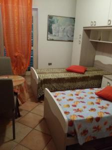 Short-lets affittacamere في Montemitro: غرفة نوم بسريرين وستارة برتقال