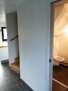a bathroom with a toilet and a room with a door at Les Mouettes in Plouër-sur-Rance