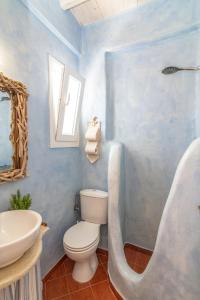 a blue bathroom with a toilet and a sink at Madalena's Family Rooms in Tinos