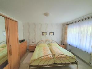 een kleine slaapkamer met een bed en een raam bij Ferienwohnung Haus Sonnenschein in Trassem