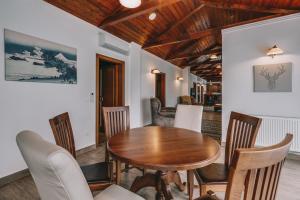 a dining room with a wooden table and chairs at Villa Tília Balatongyörök in Balatongyörök
