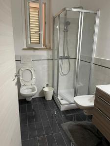 a bathroom with a shower and a toilet and a sink at Appartamenti Romita in Cupra Marittima